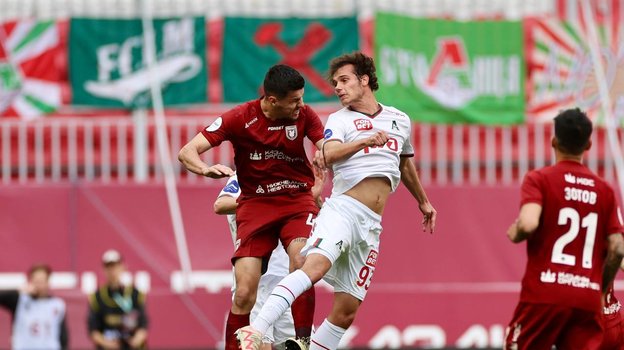 Полузащитник «Локомотива» Антон Карпукас в борьбе за мяч с форвардом «Рубина» Мирлиндом Даку.