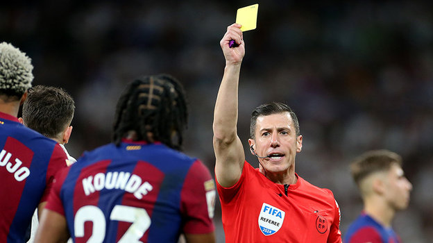 Судья Сото Градо показывает желтую карточку Жулю Кунде.