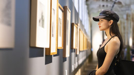 Девушка в музее смотрит на картину.