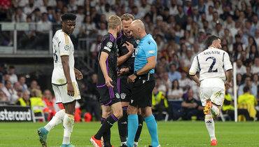 Футболисты «Баварии» Харри Кейн и Маттейс де Лигт спорят с главным арбитром Шимоном Марчиняком.