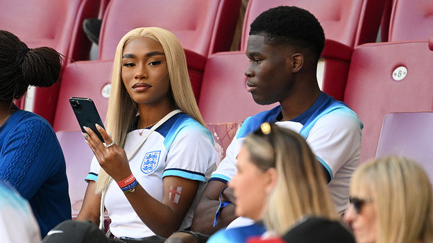 Толами Бенсон поддерживает Букайо Саку на трибуне.