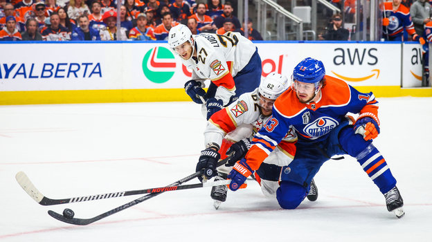 Нападающий «Эдмонтона» Маттиас Янмарк борется за шайбу с защитником «Флориды» Брэндоном Монтуром.