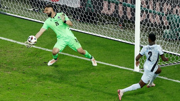 Голкипер сборной Грузии Георгий Мамардашвили отбивает удар по своим воротам в матче с Португалией.