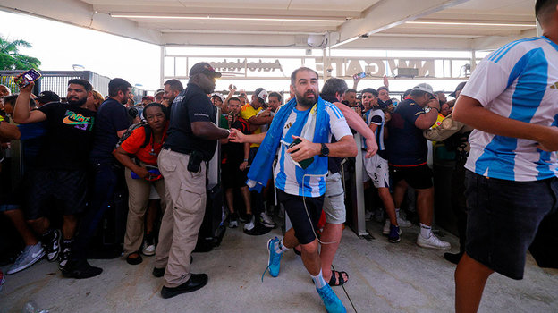 Болельщики прорываются через заграждения.