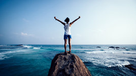 Девушка стоит на краю скалы