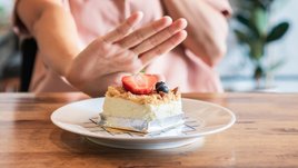 Девушка отказывается от пирожного.