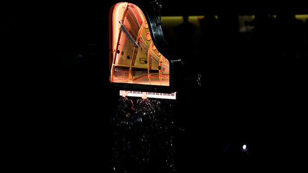 Алан Роше исполняет «Гимн Аполлону» на рояле, подвешенном в воздухе.