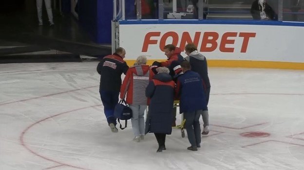 Даниила Вовченко увозят на носилках со льда.