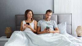 Женщина смотрит в телефон мужа