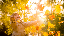 Ребенок играет листьями