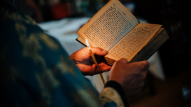 Православный священник читает Библию