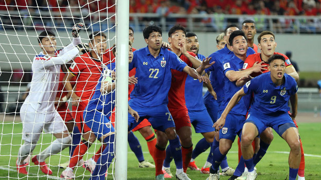 Футболисты сборной Таиланда (в синем) в матче против Китая.