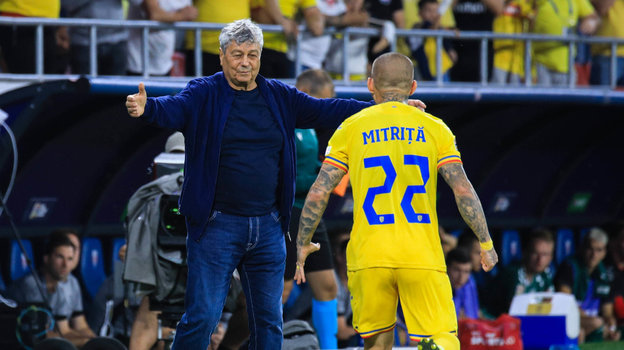 Футболист сборной Румынии Александру Митрицэ бежит праздновать гол в ворота Литвы к Мирче Луческу.