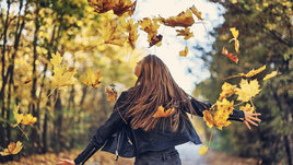 Девочка-подросток наслаждается осенними листьями
