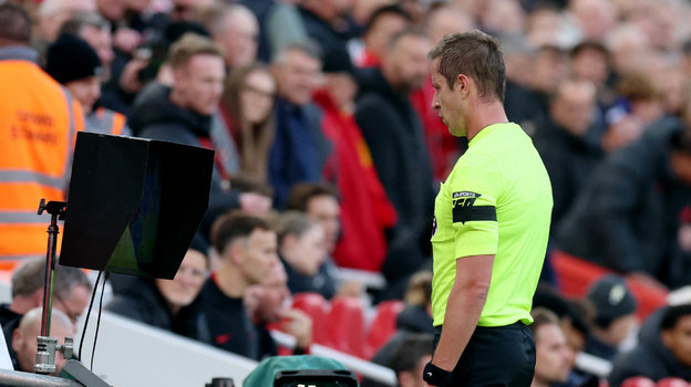 Главный арбитр матча «Ливерпуль» — «Челси» Джон Брукс просматривает повтор после вмешательства ВАР.