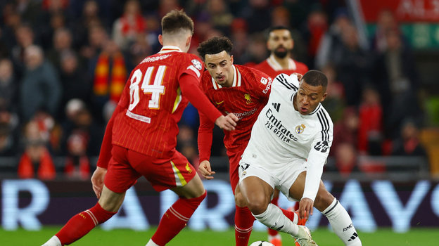 Футболист «Реала» Килиан Мбаппе против игроков «Ливерпуля» Кертиса Джонса и Конора Брэдли.