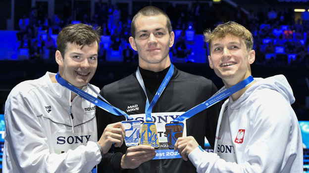 Хуберт Кош, Мирон Лифинцев и Кацпер Стоковский на награждении после 100 м на спине на ЧМ-2024.