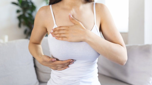 Женщина трогает грудь