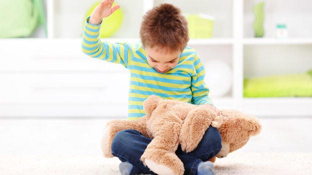 Ребенок бьет игрушку.