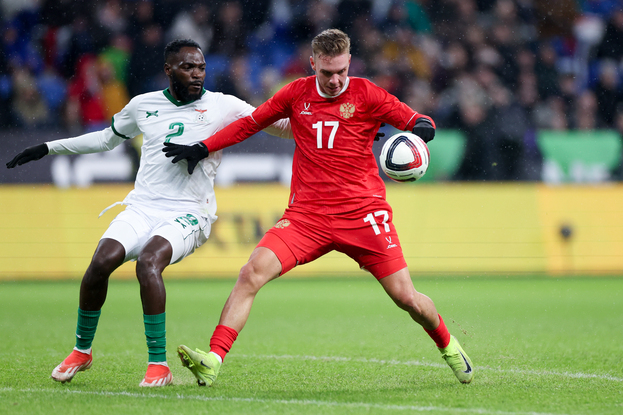 Максим Глушенков (с мячом) против футболиста сборной Замбии Кебсона Каманга.