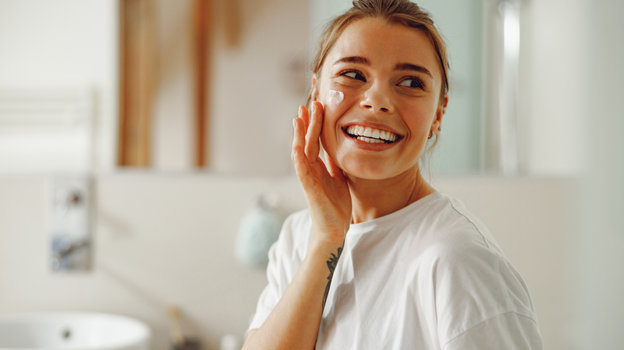 Девушка наносит крем