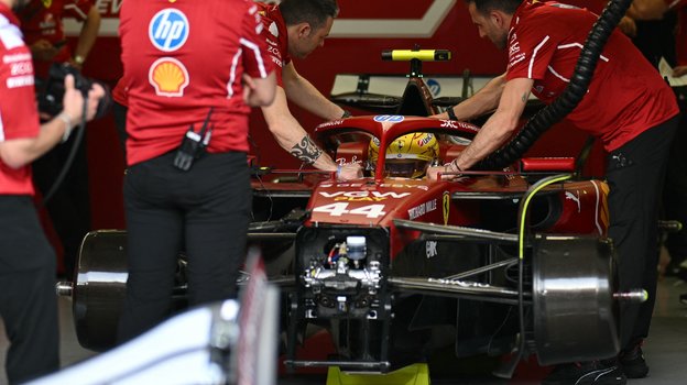 Болид Льюиса Хэмилтона в боксах в паддоке трассы в Сахире.