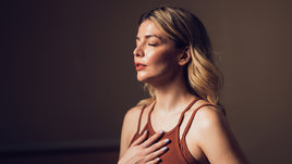 Девушка делает дыхательное упражнение