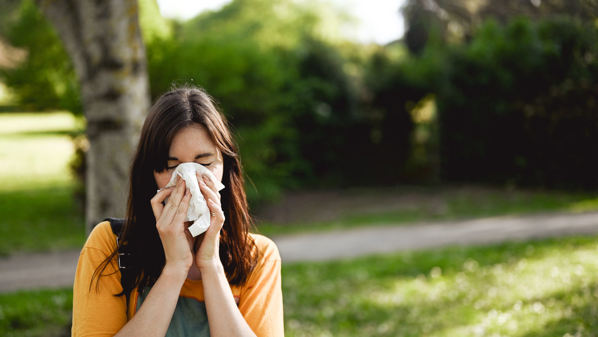Девушка чихает на улице