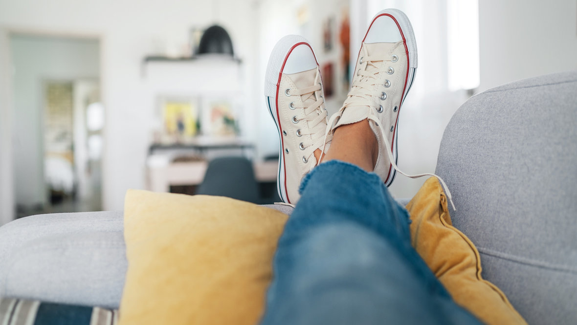 Женские ноги в кедах на диване