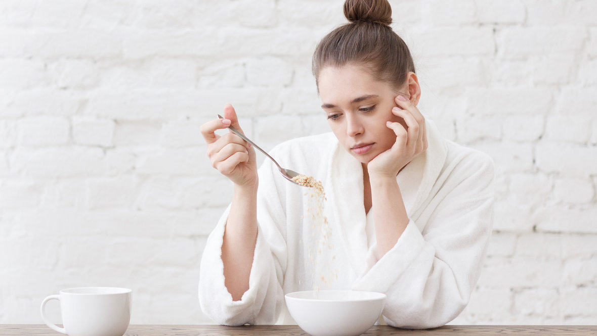 Девушка грустит и смотрит на еду