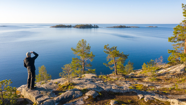 Мужчина на скалистом острове с соснами