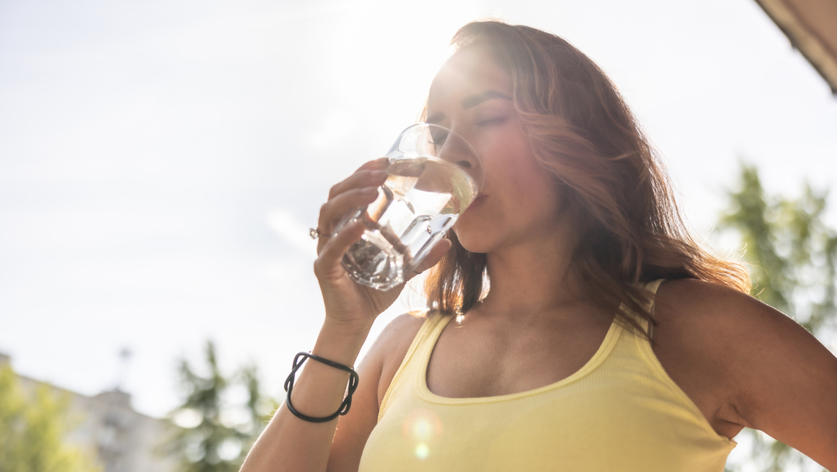 Девушка пьет воду в жару