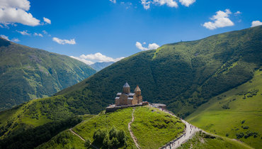 Троицкая церковь Гергети на фоне Кавказских гор в Грузии