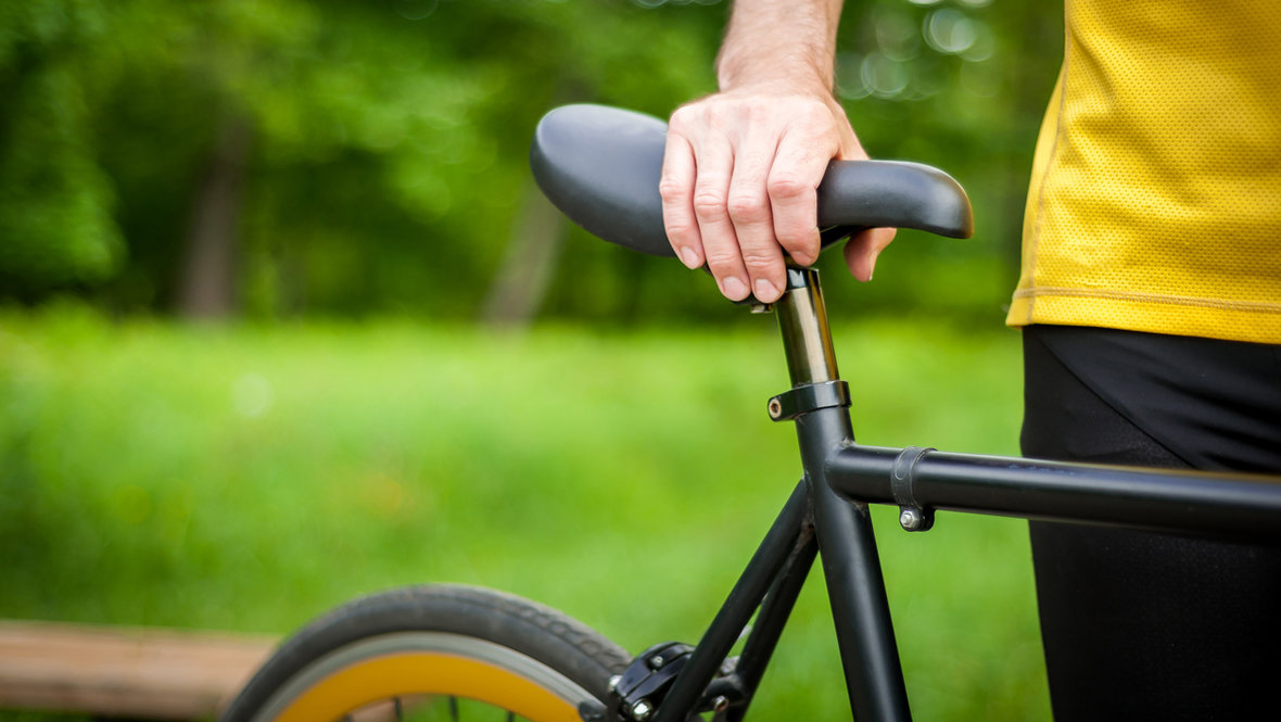 Велосипедист держит велосипед