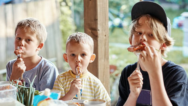 Дети едят шашлык