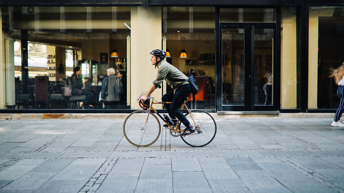 Мужчина среднего возраста ездит на велосипеде по городу