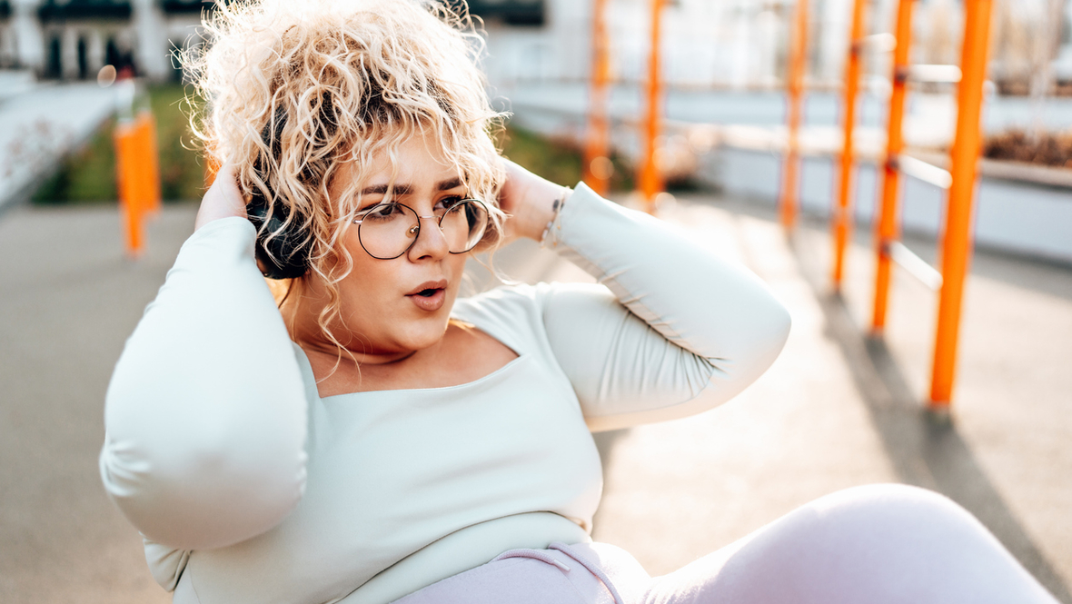 Полная девушка делает упражнение на пресс