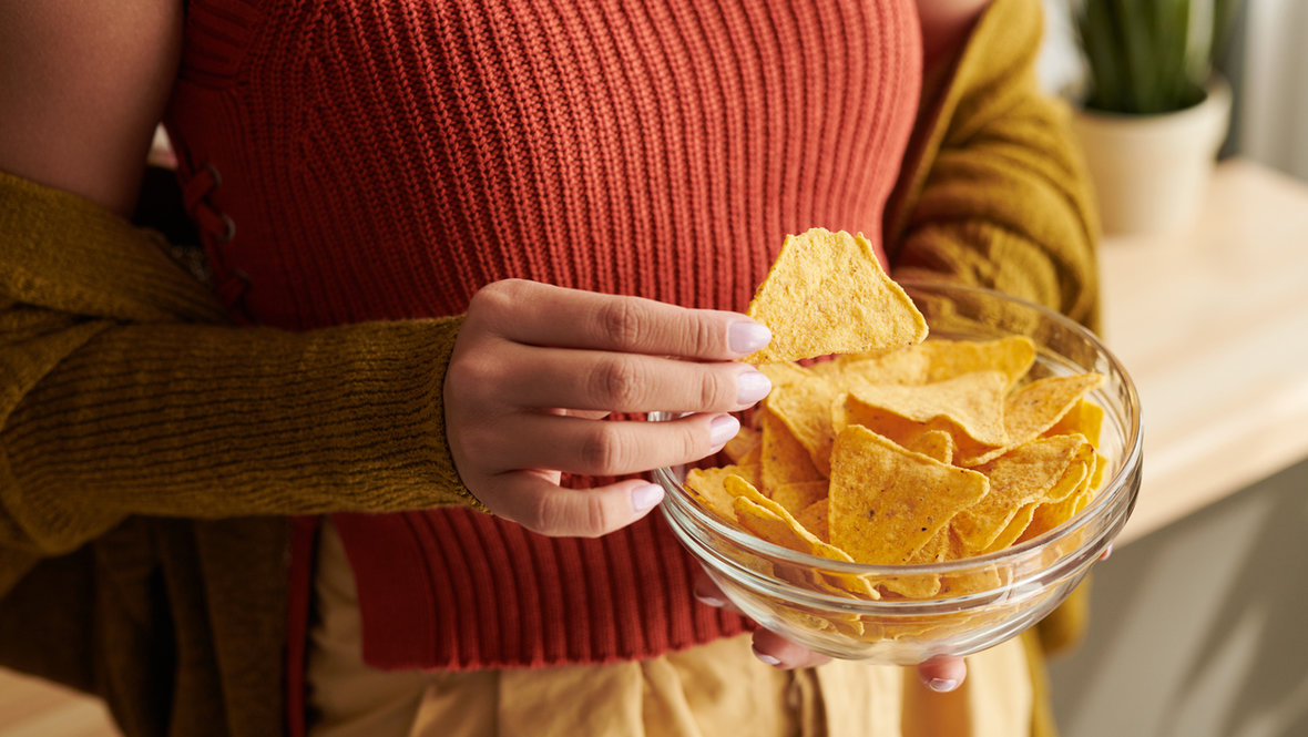 Девушка держит миску чипсов