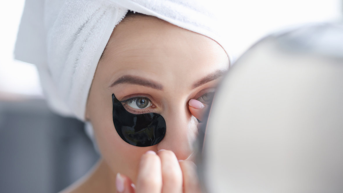 Девушка наносит патчи перед зеркалом