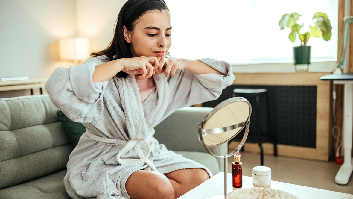 Девушка делает себе массаж лица.