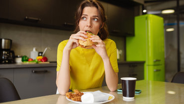 Девушка ест бургер