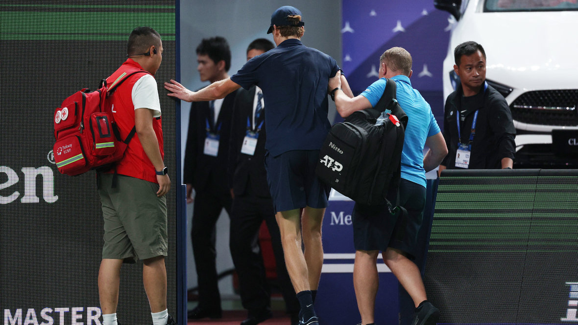 Яннику Синнеру помогают покинуть корт в Шанхае.