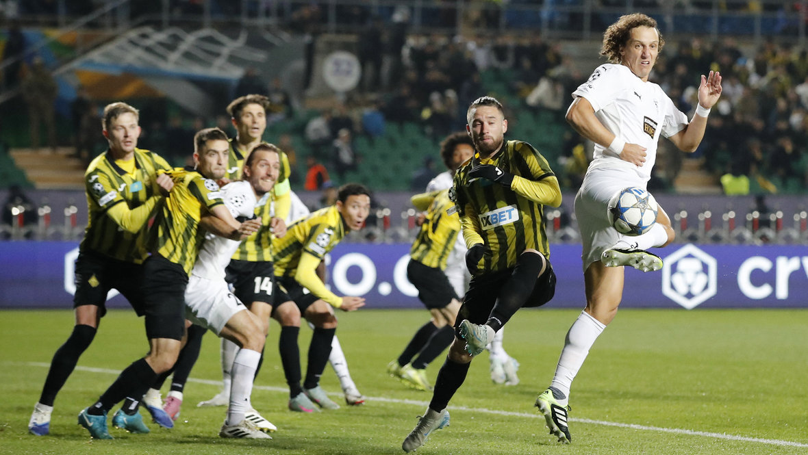 Защитник «Пафоса» Давид Луиз (справа) бьет пяткой по воротам «Кайрата».