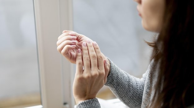 Девушка смотрит на ногти