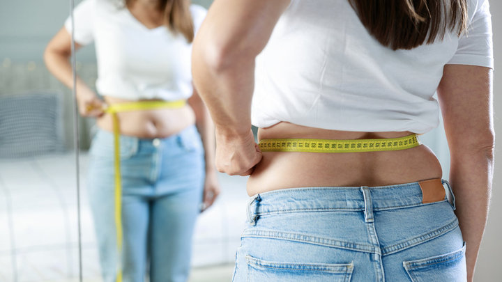 Девушка делает замеры талии