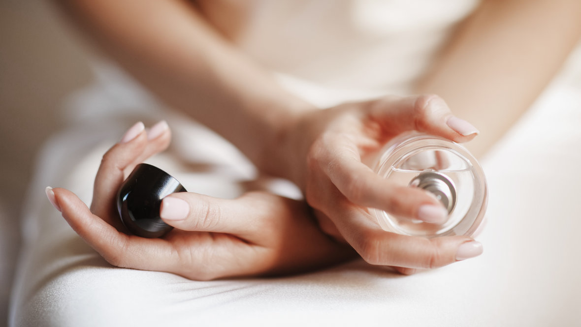 Девушка держит флакон с духами