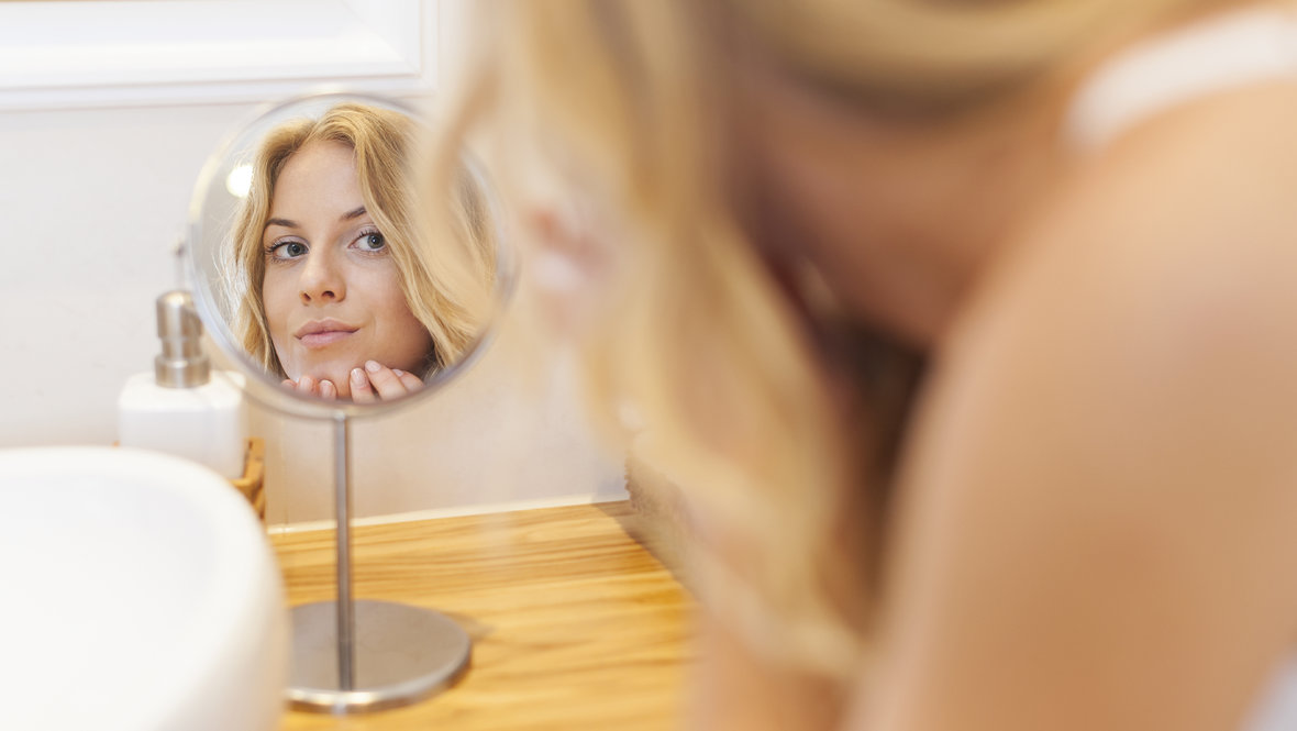 Девушка смотрится в зеркало