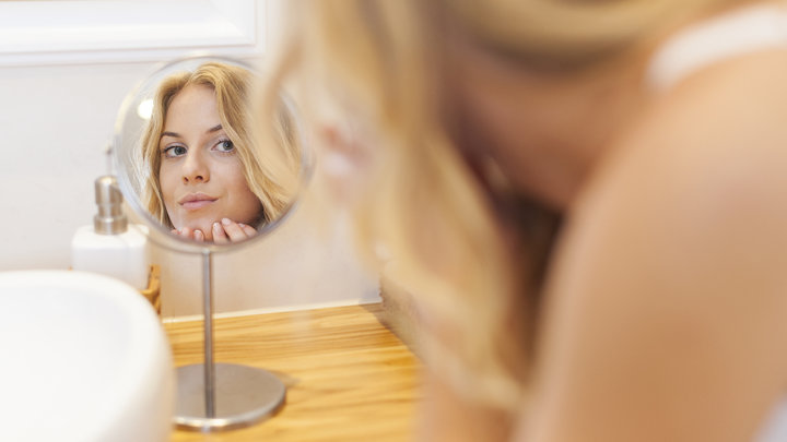 Девушка смотрится в зеркало