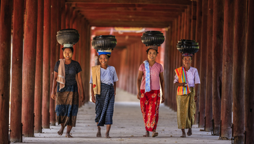 Бирманские женщины, несущие миски риса в монастырь