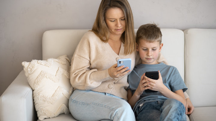 Мать и сын сидят в телефонах